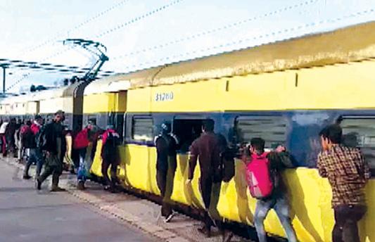 Passengers pushing train carriages due to engine fire in UP