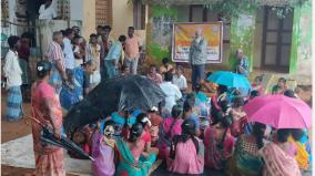 participating-villagers-in-tinkuppam-panchayat-holding-umbrellas-in-the-rain