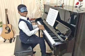 a-9-year-old-boy-plays-the-piano-with-closed-eyes