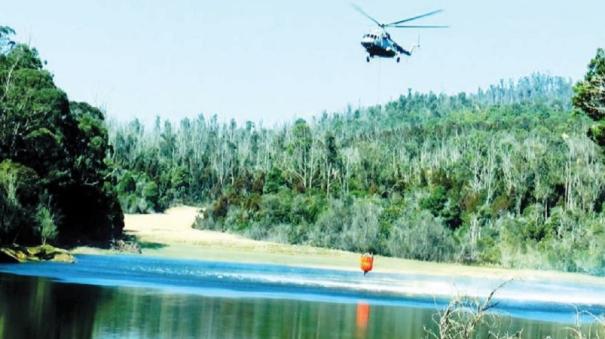 work of extinguishing the forest fire with water by helicopter is intense