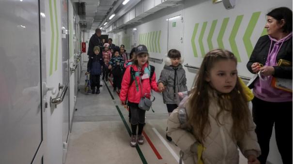 Kids attend Ukraine’s first bunker school, down concrete staircase, crossing two doors