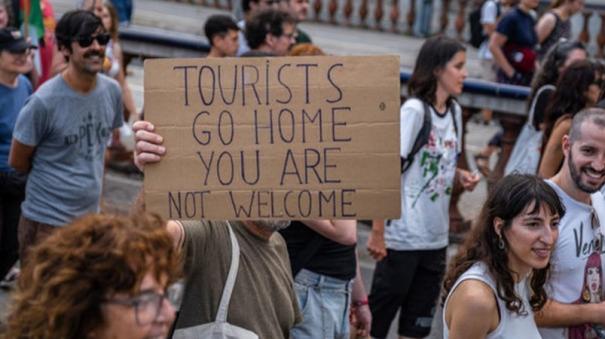 people of Spain asking the tourists to leave