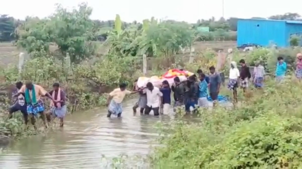 due-to-huge-downpour-relatives-carrying-the-dead-one-in-knee-deep-water-at-pazhani